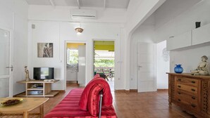 A spacious living area with a sofa, TV, and wooden furniture. - Villa Kavich - Two Bedroom Villa, Sleeps 4 (Les Trois-Îlets)