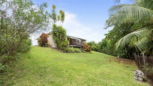 A house with a wooden deck and a grassy yard surrounded by various plants and trees. - Villa Kavich - Two Bedroom Villa, Sleeps 4 (Les Trois-Îlets)