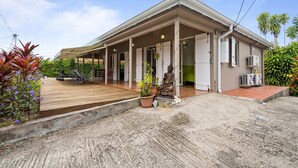 A two-story building with a covered porch, outdoor seating, and a statue. - Villa Kavich - Two Bedroom Villa, Sleeps 4 (Les Trois-Îlets)