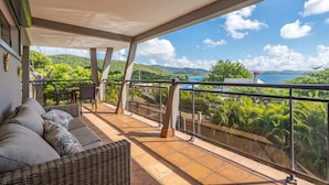 A balcony with wicker furniture and a view of a mountainous landscape. - Villa Kaléna - Four Bedroom Villa, Sleeps 9 (Le Diamant)
