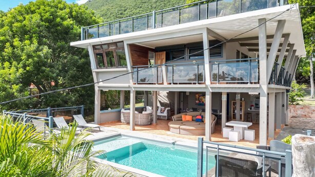 A modern two-story house with a swimming pool, outdoor seating, and a view of a forested hill. - Villa Kaléna - Four Bedroom Villa, Sleeps 9 (Le Diamant)
