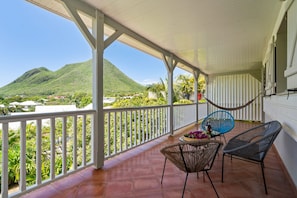 Ein überdachter Balkon mit Blick auf einen Berg und eine Stadt.