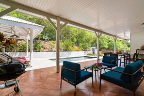An outdoor patio with a pool, seating area, and a grill. - Villa Dizac - Five Bedroom Villa, Sleeps 10 (Le Diamant)