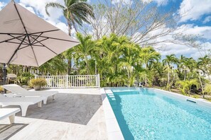 A swimming pool with a white deck, surrounded by palm trees and a white fence. - Villa Serenity - Four Bedroom Villa, Sleeps 8 (Les Trois-Îlets)