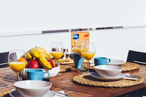 A breakfast table with fruit, juice glasses, and a box of Koffin cereal. - Casa Monash (Puerto del Carmen)