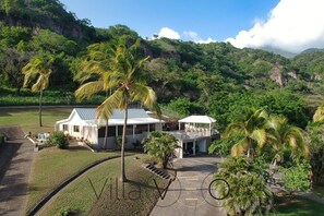 Set amidst lush greenery and palm trees, this resort offers a serene escape with a paved walkway leading to its main building.