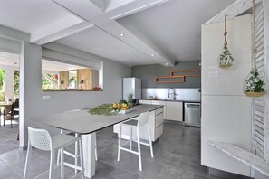 Enjoy cooking in this sleek kitchen with a central island, bar stools, and bench.