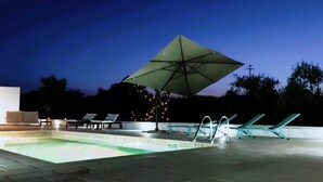 A swimming pool with lounge chairs and an umbrella. - Villa Gabriella con Piscina by Wonderful Italy (Ostuni)
