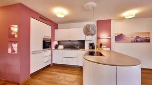 A modern kitchen with white cabinets, a central island, and pendant lighting.