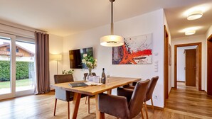 A modern dining area with a wooden table, leather chairs, and a pendant light.
