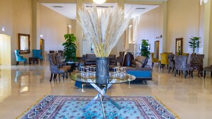 A spacious lobby with a central glass table, sofas, and chairs arranged around it. - URBAN LIFESTYLES HOTEL (Masvingo)