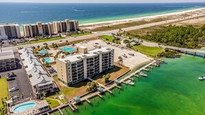 A coastal hotel with multiple buildings, a marina, and a beach. - Wind Drift Orange Beach - Bay Views - Boat Slips - 3BR Dual-Waterfront Sleeps 11 (Orange Beach)