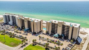 A beachfront hotel with multiple buildings, a parking lot, and a pool area. - Wind Drift Orange Beach - Bay Views - Boat Slips - 3BR Dual-Waterfront Sleeps 11 (Orange Beach)