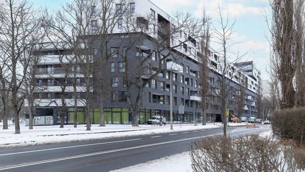 Un immeuble à plusieurs étages, doté d’un style architectural moderne, qui présente un mélange de balcons et de grandes fenêtres.