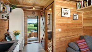 Un intérieur en bois comprenant un coin cuisine, un canapé et une bibliothèque.