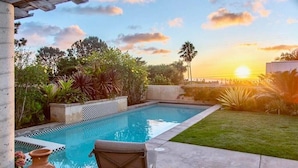 A swimming pool with a view of the sunset, surrounded by greenery and a patio area. - Ocean View Villa w/ Pool + Spa (Solana Beach)