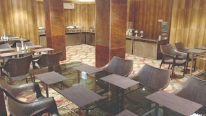 A hotel lobby with a central bar area, seating arrangements, and a patterned carpet. - The Royal Suite (Bhubaneshwar)