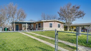 A fenced yard with a pathway leading to a two-story house with a covered porch. - San Antonio Home Near AFB & Hospitals: WFH Welcome (San Antonio)