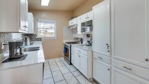 A kitchen with white cabinets, a stove, and a sink. - San Antonio Home Near AFB & Hospitals: WFH Welcome (San Antonio)