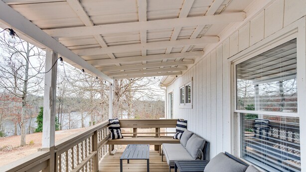 A covered porch with a wooden bench, a small table, and a sofa. - Lakefront Getaway w/ Porch in Athens Area! (Statham)