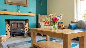 Un salon chaleureux avec une cheminée, une table basse en bois et un canapé.