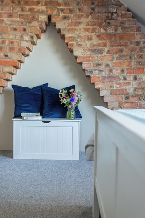 A room with a white bench, a brick wall, and a white railing. - Sea View Coastal Cottage Sleeps 6 | Jurassic Coast, 6-Min Walk to Beach, Dogs (Fortuneswell)