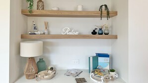 Een plank met decoratieve objecten, een lamp en boeken.