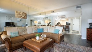 A spacious living room with a large sectional sofa, a coffee table, and a patterned rug.