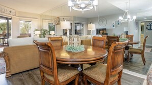 A dining area with a round wooden table, six chairs, and a chandelier.