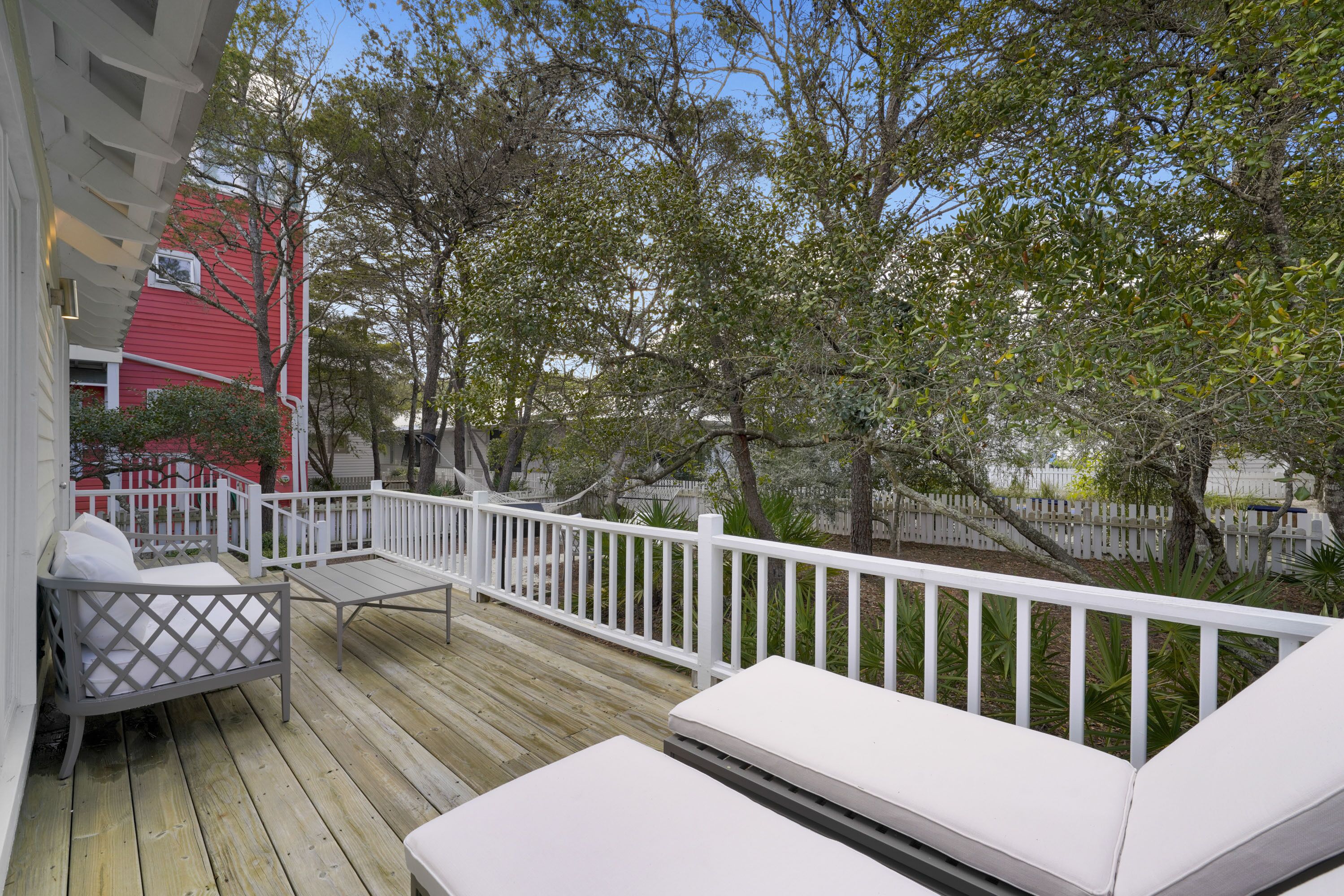 A wooden deck with white railings and outdoor furniture.