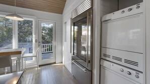 A modern kitchen with stainless steel appliances, a wooden ceiling, and a view through a glass door. - Just Six Houses to the Beach in Seaside, FL + 2 Adult Bikes! (Santa Rosa Beach)