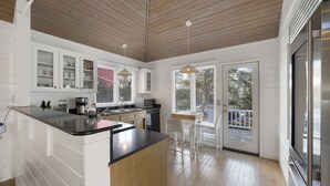 A modern kitchen with white cabinets, a black countertop, and wooden flooring. - Just Six Houses to the Beach in Seaside, FL + 2 Adult Bikes! (Santa Rosa Beach)