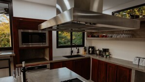 Una cucina moderna con forno a microonde integrato, piano cottura e finestra con vista sul verde.