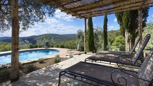 A poolside area with a pergola, lounge chairs, and a view of the mountains. - Casolare di Rietine, Gaiole in Chianti, Siena and Chianti (Gaiole in Chianti)