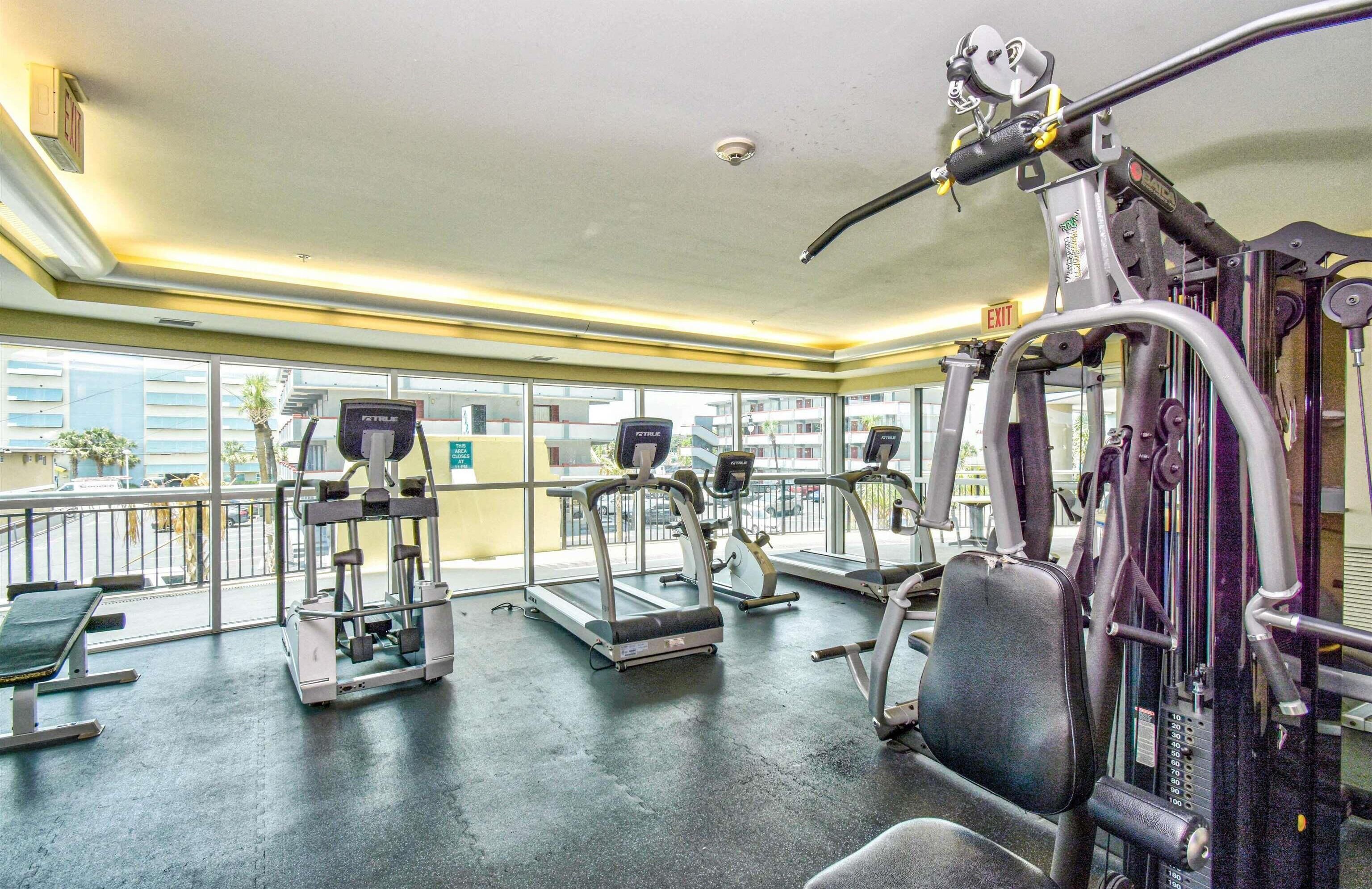 A gym with treadmills, weight machines, and a bench.