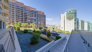 A residential building with multiple balconies, a playground, and a landscaped garden area.