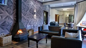 Een moderne woonkamer met een open haard, banken en een eethoek.