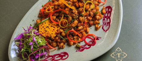 A plate of food with chickpeas, vegetables, and garnishes.