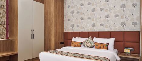 A modern bedroom with a large bed, wooden wardrobe, and a patterned wall.