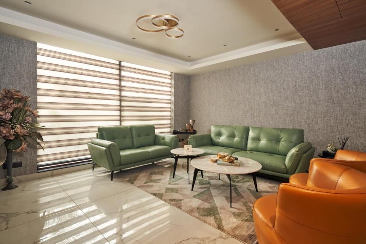 A modern living room with a sectional sofa, a coffee table, and a pair of armchairs.