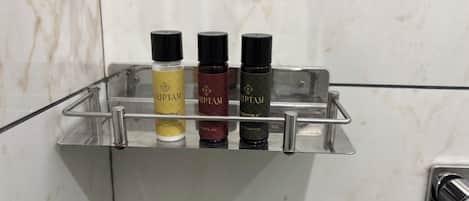 Un estante en el baño con tres botellas de productos capilares Triptam.