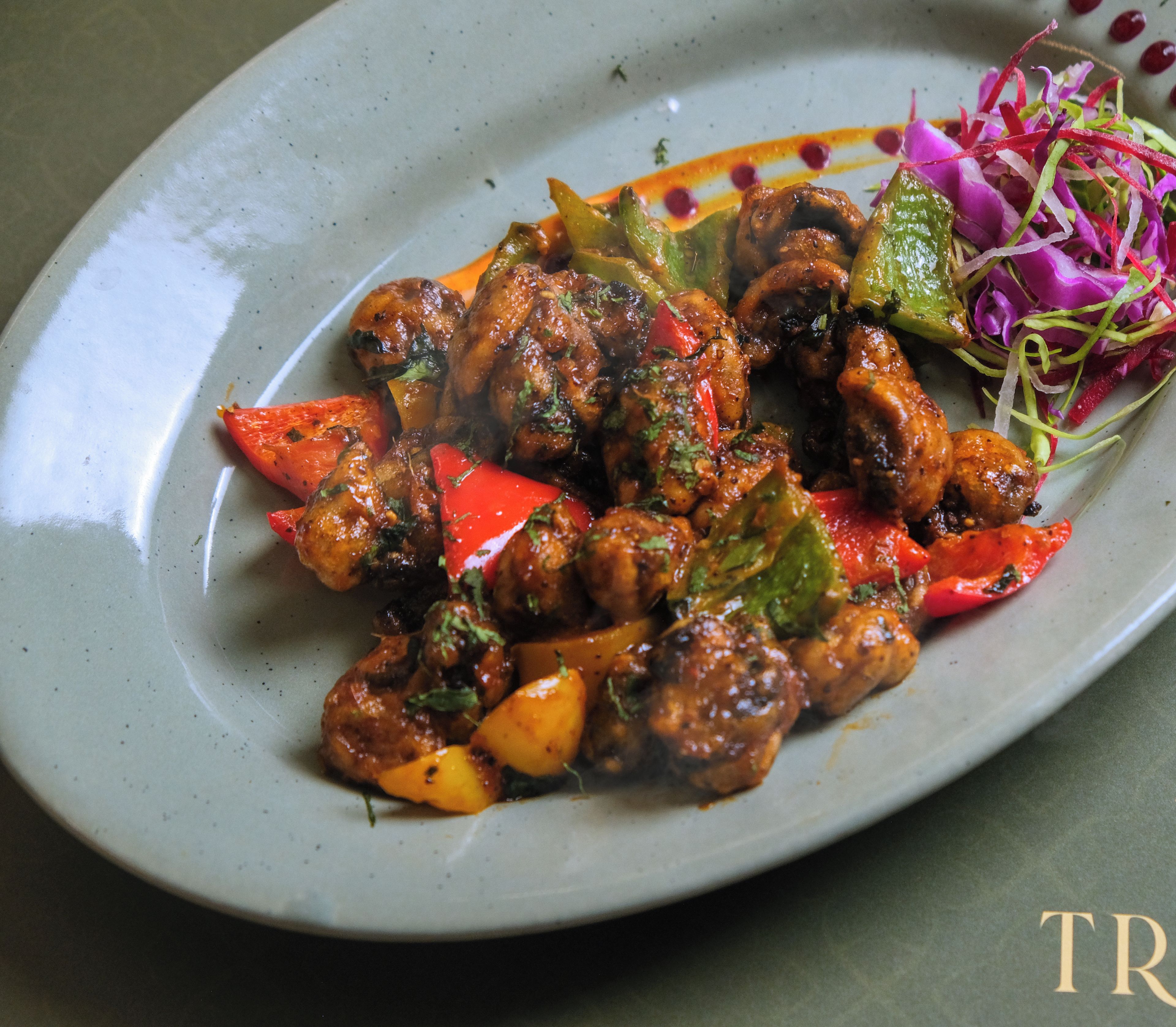 A plate of stir-fried meat with vegetables and a side salad.