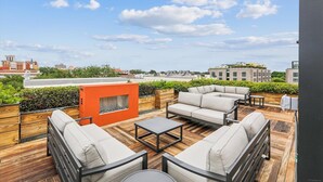 Une terrasse sur le toit avec des sièges extérieurs, un foyer et une vue sur le paysage urbain.