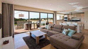 Een moderne woonkamer met een bank, bijzettafeltje en uitzicht op de omgeving.