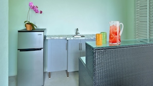 A kitchenette with a refrigerator, sink, and a wicker table with a pitcher of drink. - Sleep 16 guests over two side-by-side homes in exclusive Key Cove Landings (Key West)