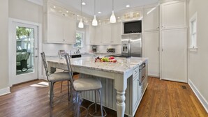 A kitchen with white cabinets, a marble island, and stainless steel appliances. - Popular location in Atlantic Beach, community pool (Kiawah Island)