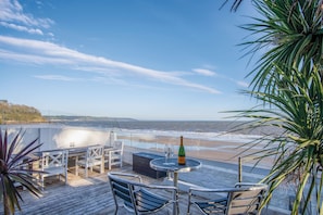 Enjoy breathtaking ocean views from this terrace, complete with a table, chairs, and bench.