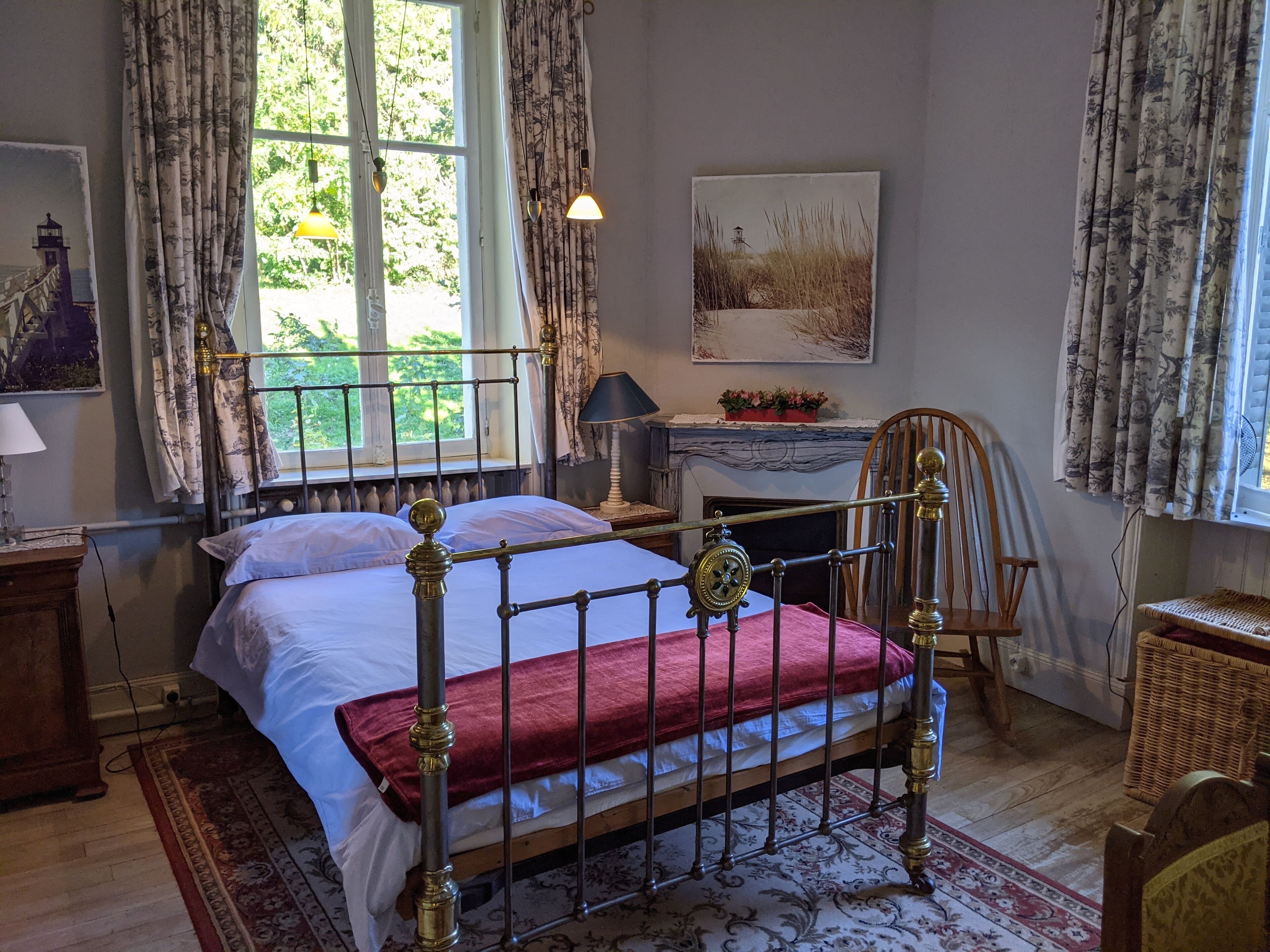 A bedroom with a bed, a desk, a chair, and a window with curtains.