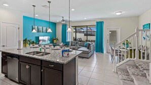 A modern kitchen with a granite countertop, double sink, and dark cabinetry.