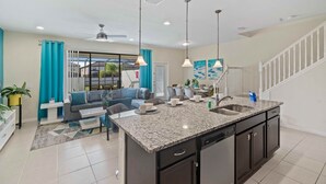 A modern kitchen with granite countertops, dark cabinetry, and a central island.